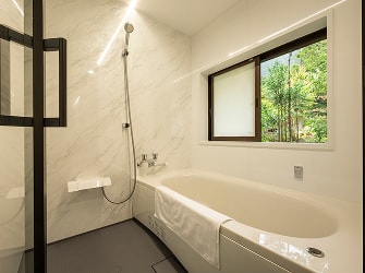 窓から緑が見える、明るく清潔感のあるバスルーム