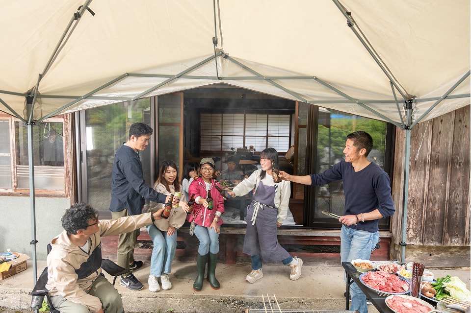 縁側で家族や友人たちとバーベキューを楽しむ様子