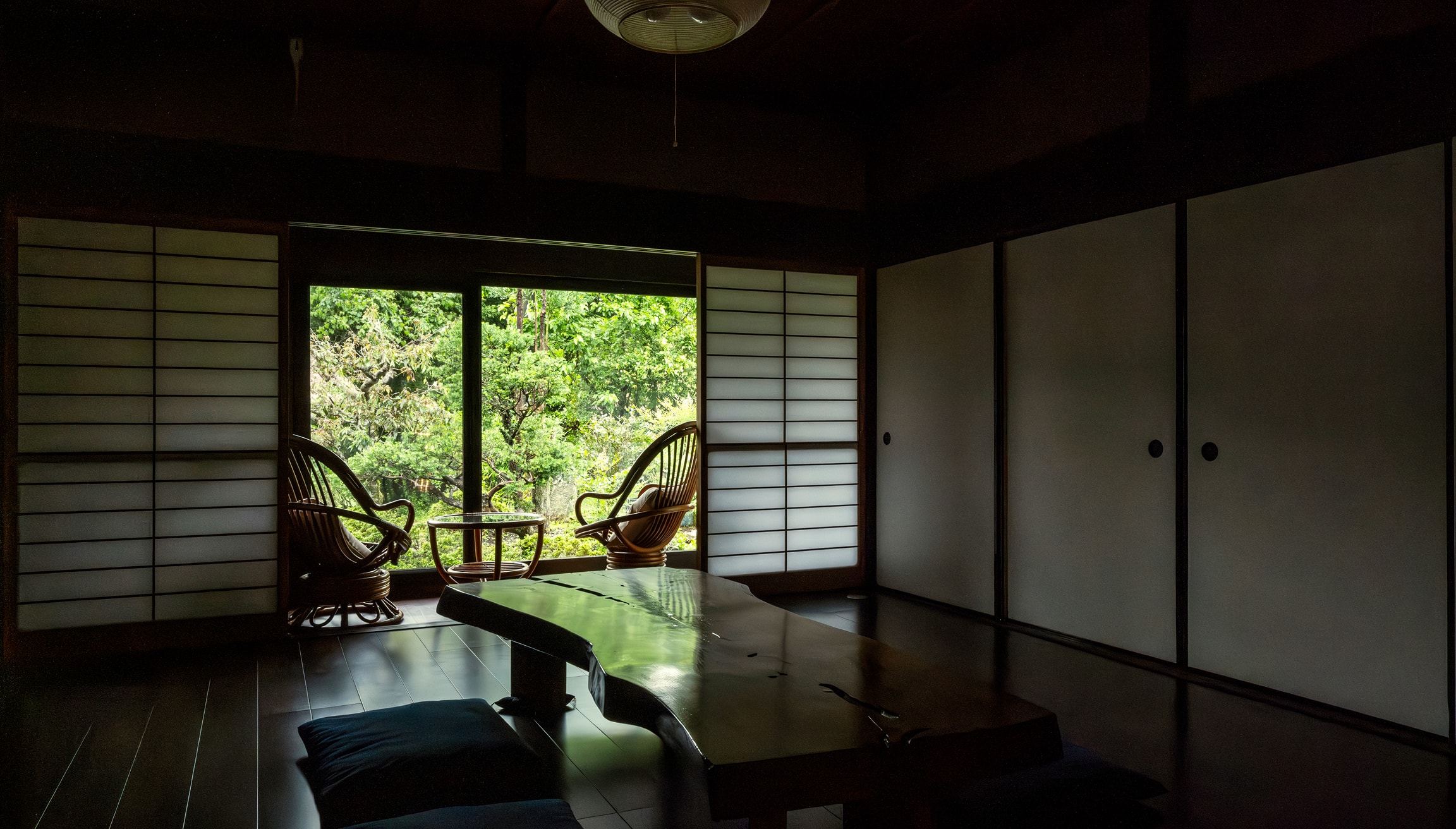 縁側に面した庭を眺められる椅子と机が置かれた落ち着いた空間