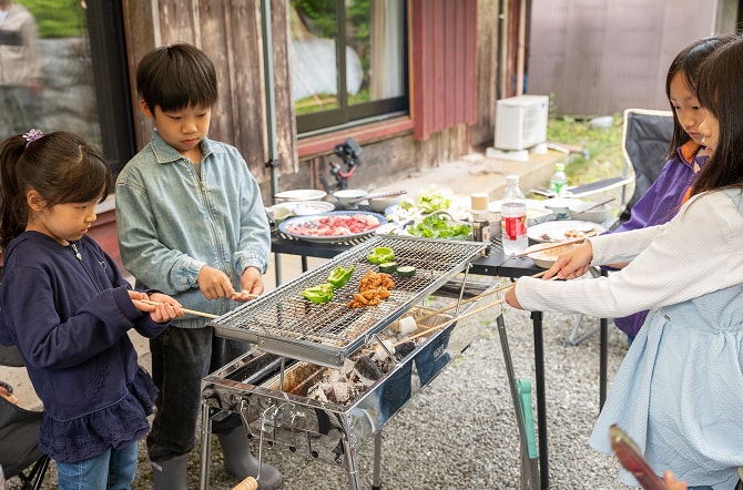バーベキューコンロを囲む子どもたち