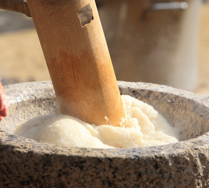 石臼でもち米をつく餅つき体験の様子